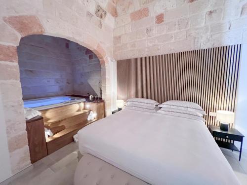a bedroom with a bed and a bath tub at DIMORA BIANCA in Triggianello