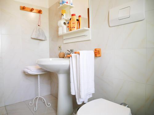 Baño blanco con lavabo y aseo en LAKEVIEW RETRAIT, en Varenna