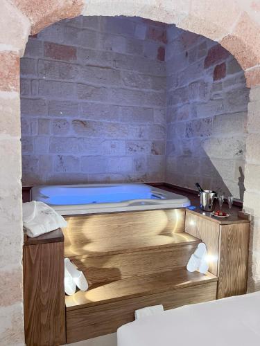 a bath tub in a room with a brick wall at DIMORA BIANCA in Triggianello