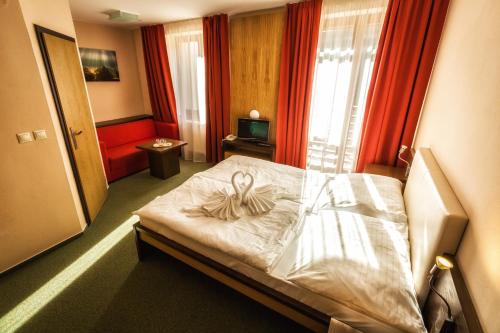 a bedroom with a bed with a bow on it at Hotel Malina-Ski Resort-SKI-IN & SKI-OUT in Ružomberok