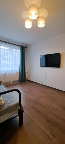 an empty room with a bed and a flat screen tv at Lauku Str.Apartment in Liepāja