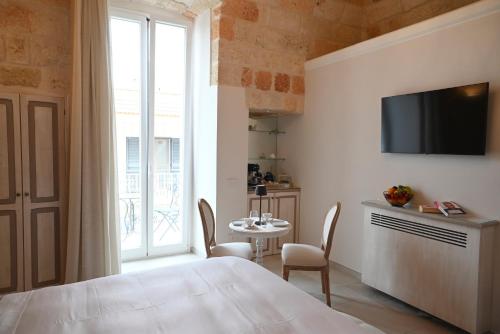 a room with a bed and a table and a window at DIMORA BIANCA in Triggianello