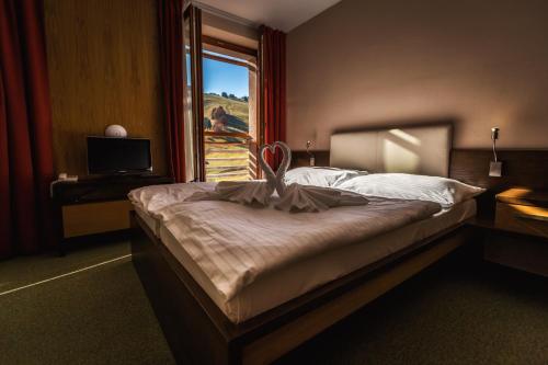 a bedroom with a large bed and a window at Hotel Malina-Ski Resort-SKI-IN & SKI-OUT in Ružomberok