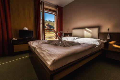 a bedroom with a large bed and a window at Hotel Malina*** in Ružomberok