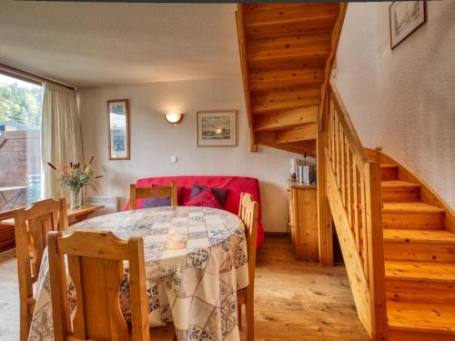 a dining room with a table and a staircase at Appartement Morillon 1100, 3 pièces, 6 personnes - FR-1-642-19 in Morillon