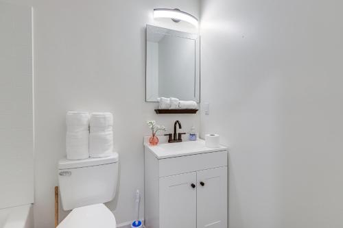 a white bathroom with a toilet and a mirror at Modern Conyers Retreat - 9 Mi to Arabia Mountain! in Conyers