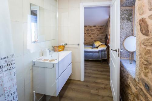 a small bathroom with a sink and a mirror at Casa Lela Dumbria in Dumbría