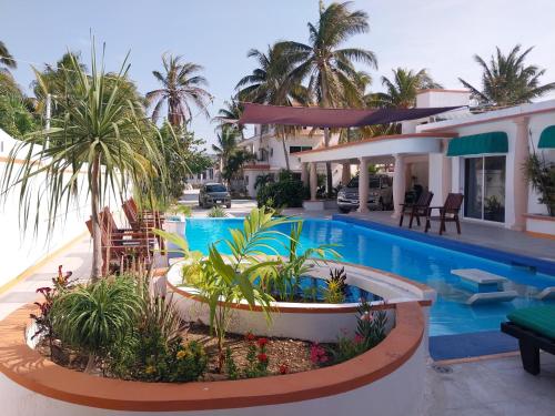 a villa with a swimming pool and a house at El Paraíso de Capitán Fernando in Chelem