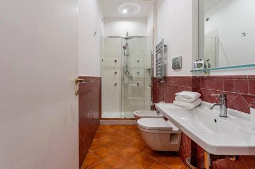 a bathroom with a sink and a toilet and a shower at Fori Imperiali Luxe Mansion in Rome
