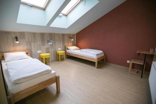 ein Schlafzimmer mit 2 Betten und 2 Hockern in der Unterkunft DREAM Hotel Lviv in Lwiw