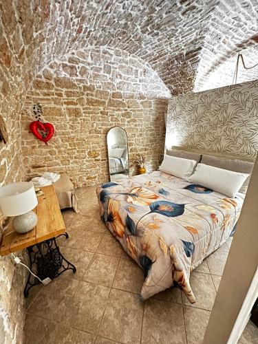 a bedroom with a large bed in a brick wall at B&B PIETRA VIVA in Sannicandro di Bari