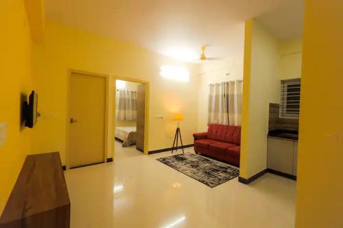 uma sala de estar com um sofá vermelho e um quarto em HSR Hillcrest by Newstays em Bangalore