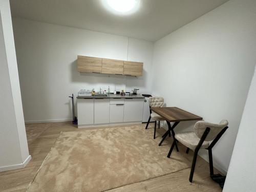 Arasta Apartments في إسكوبية: مطبخ مع طاولة وكراسي في غرفة
