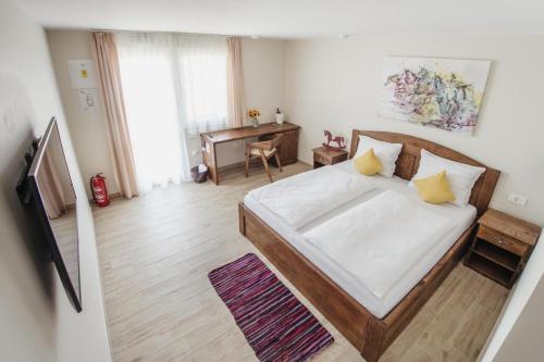 1 dormitorio con 1 cama con sábanas blancas y almohadas amarillas en Ranč Ramarin en Garčin