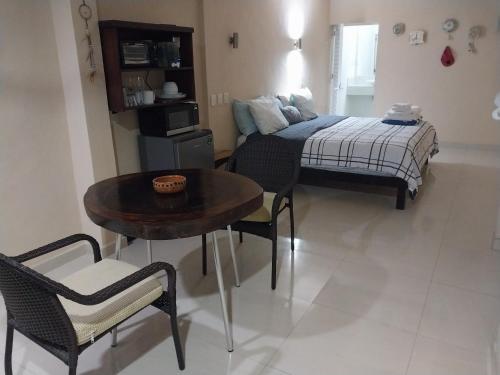 a bedroom with a bed and a table and chairs at El Paraíso de Capitán Fernando in Chelem