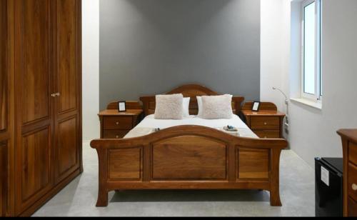a bedroom with a wooden bed with two night stands at Privilege Suite Pieta in Tal-Pietà