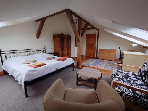 ein Schlafzimmer mit einem Bett, einem Stuhl und einem Sofa in der Unterkunft Ferienwohnungen Villa Haniel Sophie in Dresden