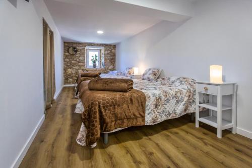 a bedroom with two beds and a stone wall at Casa Lela Dumbria in Dumbría