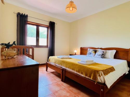 a bedroom with a bed and a window at Beach & Pool House @ Mindelo in Vila Chã