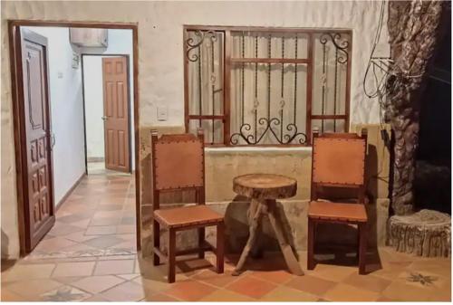 a room with two chairs and a table and a gate at Cabaña Cueva del Zorro in Ráquira
