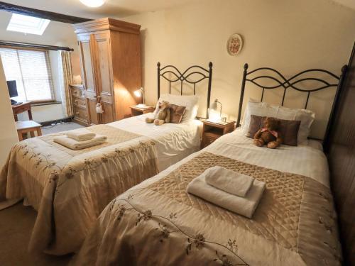 a bedroom with two beds with teddy bears on them at Springwell Cottage in Ambleside
