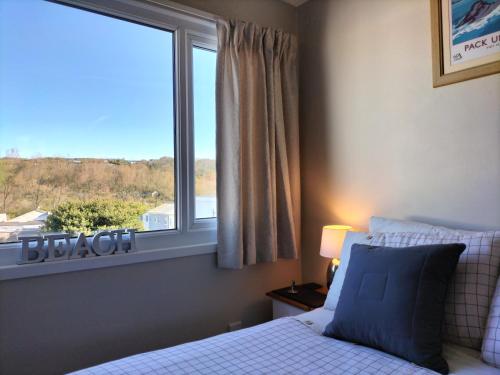 a bedroom with a bed and a large window at 34 Freshwater Bay in Hodgeston