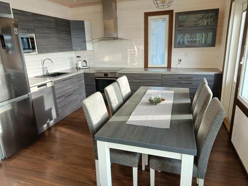 eine Küche mit einem Tisch und Stühlen in der Unterkunft Rantatähti Villa in Syöte