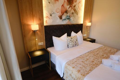 a hotel room with a bed and two lamps at PARKHOTEL - Rosarium in Uetersen