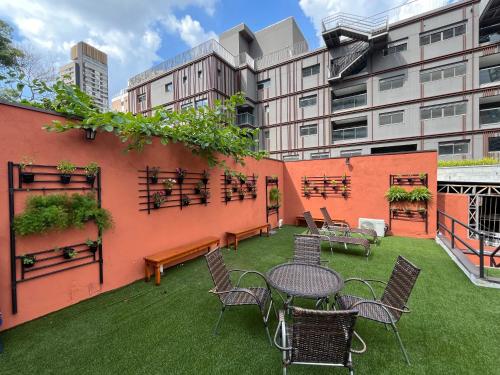 a patio with tables and chairs and a building at Bistu Hotel - Vila Nova Conceição in Sao Paulo