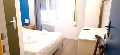 a bathroom with two white beds and a mirror at Hôtel Le Saint Quentin in Saint-Quentin