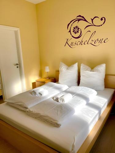 1 dormitorio con 1 cama blanca y un cartel en la pared en RAHA Apartments - Historischer Charme direkt am Domplatz, en Erfurt