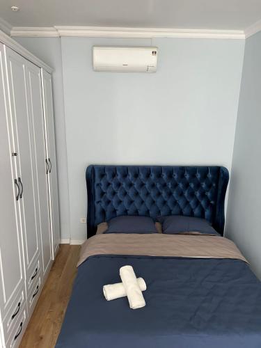 um quarto com uma cama azul com duas toalhas brancas em Жилой комплекс Легенда em (( Gornyy Gigant ))