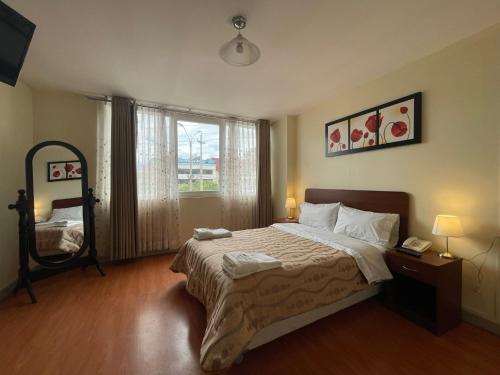 Un dormitorio con una cama grande y una ventana en Gran Kunturwasi Hotel Corporativo, en Cajamarca