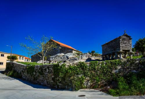 a stone wall with a church behind a building at Casa Lela Dumbria in Dumbría