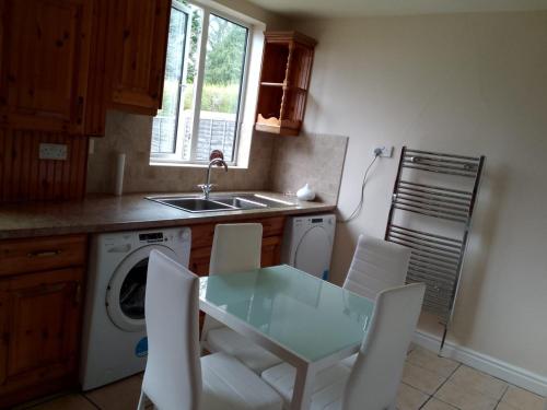 a kitchen with a table and chairs and a sink at Solihull Guest House 1 in Olton