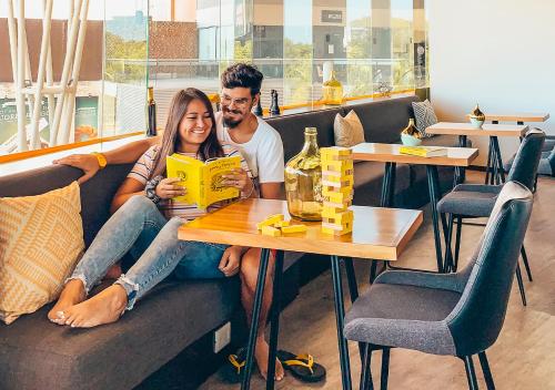 Un uomo e una donna seduti a un tavolo in un ristorante di The Yellow Capsule Hotel Close to Airport a Cancún