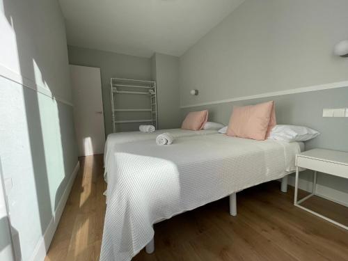 a bedroom with a white bed with pink pillows at Acariciando la Catedral Vista espectacular in Burgos