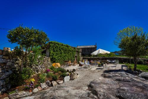a stone patio with a table and chairs at Casa Lela Dumbria in Dumbría