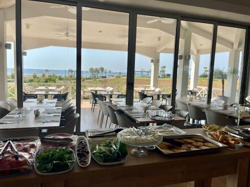 a restaurant with tables and chairs with food on them at Relaxing Penthouse Suites by the Sea in Vokolidha