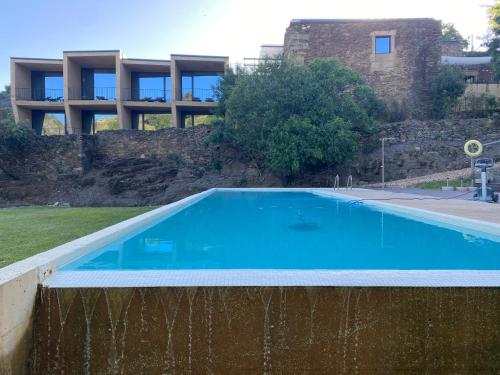 an empty swimming pool in front of a building at Colmeal Countryside Hotel in Figueira de Castelo Rodrigo
