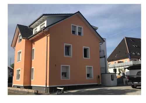 a large orange building in a parking lot at Bodensee Sunshine Zimmer & Apts. in Uhldingen-Mühlhofen
