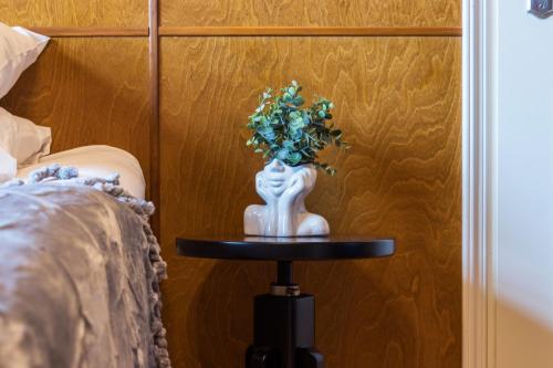 a white vase on a table next to a bed at Kadriorg by Rikas Hotels in Tallinn