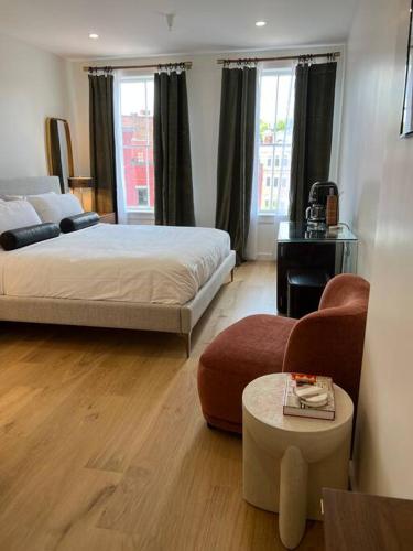 a hotel room with a bed and a chair at The Phenix, Historic DTWN Hotel, Market Square View, King Bed, Room # 400 in Bangor