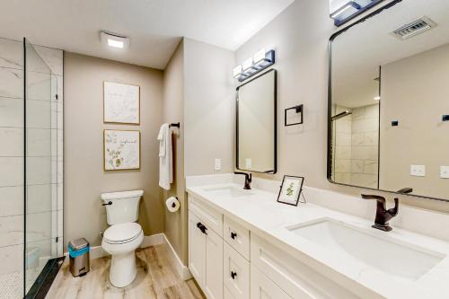 a bathroom with a toilet and a sink and a mirror at Sunrise Bay Escape in Fort Myers Beach