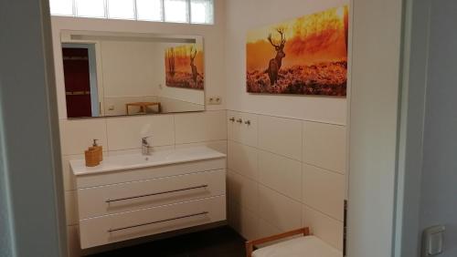 uma casa de banho com um lavatório e um espelho em Ferienwohnung "Haus am Weifberg" Hinterhermsdorf em Sebnitz