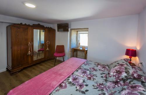 a bedroom with a bed and a cabinet and a chair at Casa Lela Dumbria in Dumbría