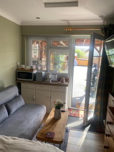 a living room with a couch and a table at Private en-suite RUTHIN in Llanfair-Dyffryn-Clwyd