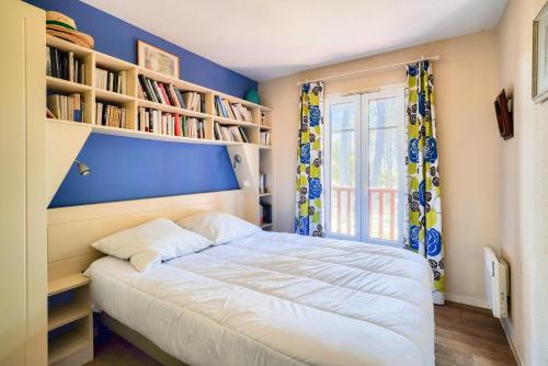 une chambre avec un lit et des étagères dans l'établissement Les Maisons de Lacanau les Pins - maeva Home - Maison 3 Pièces 8 Personnes Prestige MAE-2879, à Lacanau