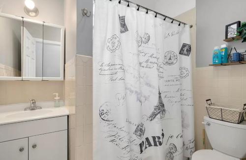 La salle de bains est pourvue d'un rideau de douche avec un écriteau. dans l'établissement Spacious 3 BR Apartment Close to Downtown, à Chicago