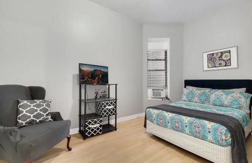 - une chambre avec un lit et une chaise dans l'établissement Spacious 3 BR Apartment Close to Downtown, à Chicago